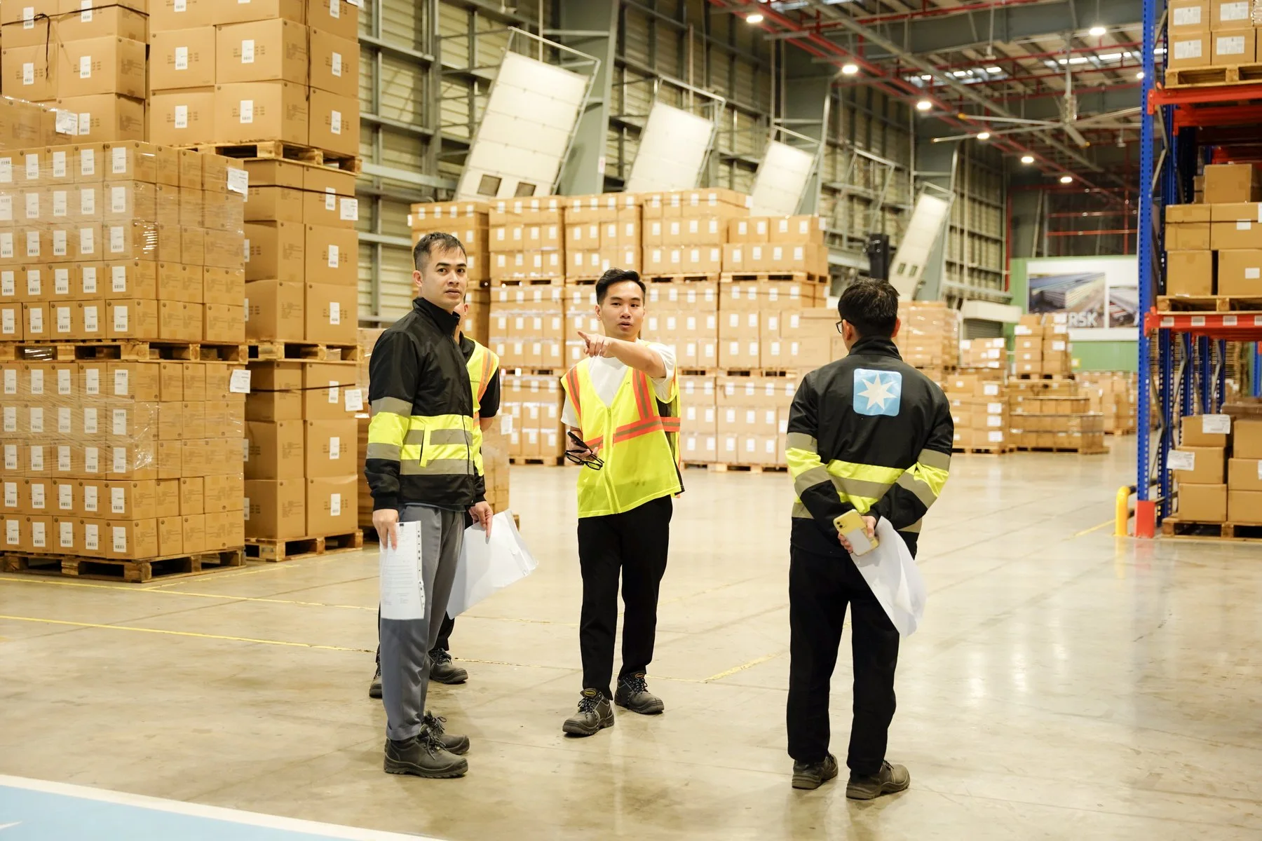 Nhóm nhân sự khảo sát giữa các dãy kệ pallet trong nhà kho